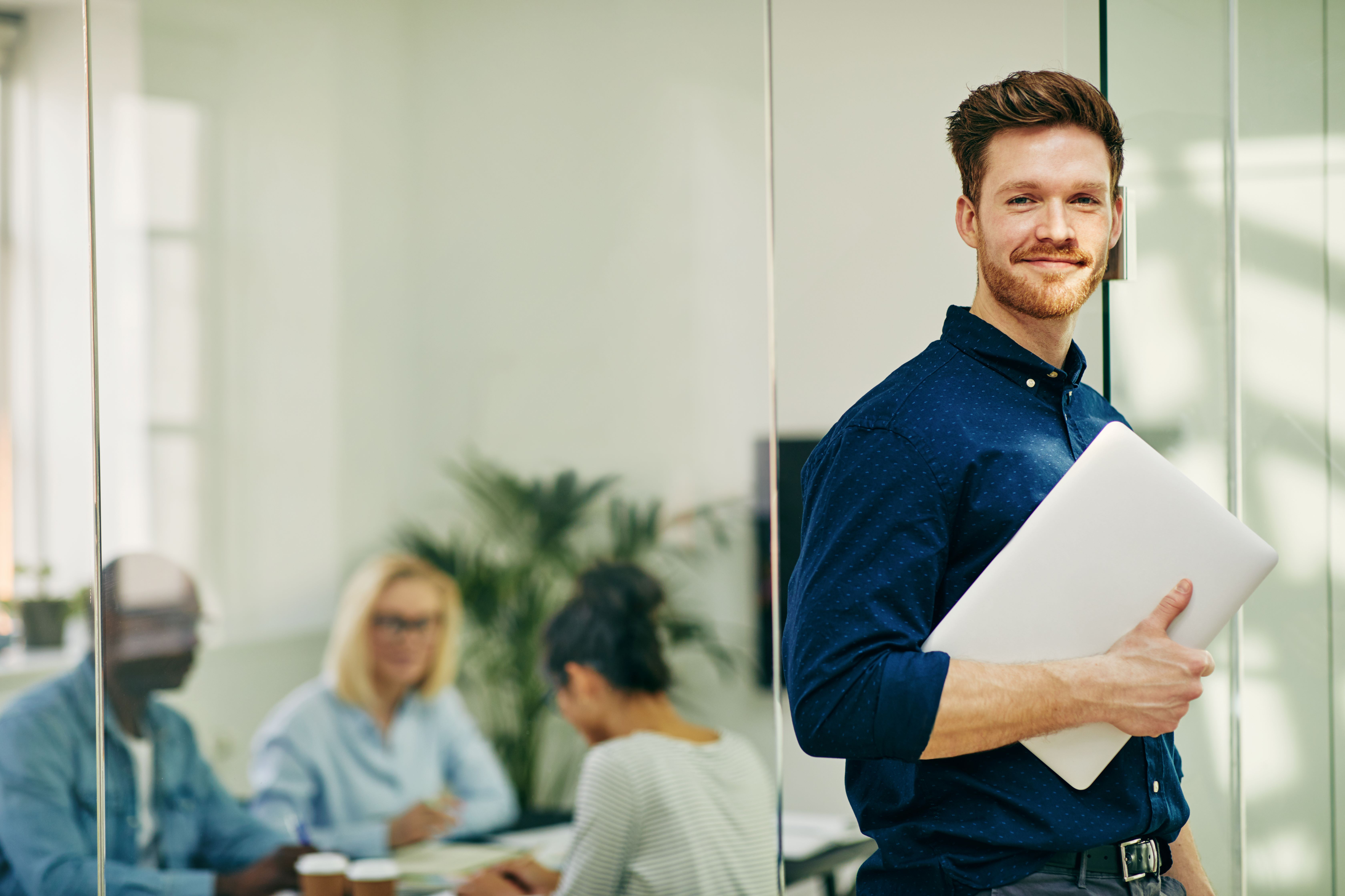 Man holding a computer in an office
