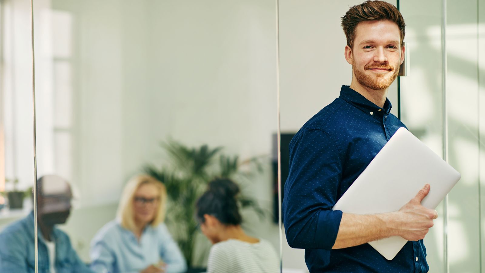 Man holding a computer in an office